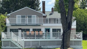 A two-story house with a balcony, a covered patio, and a basketball hoop. - Lakefront Escape on Highland (Winchester)