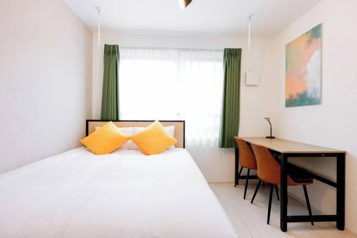 A hotel room with a bed, a desk, and a chair.