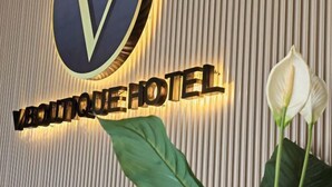 Un letrero de hotel con el nombre "VANTIQUE HOTEL" y un logotipo encima.