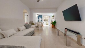 A modern living room with a sofa, a dining area, and a TV mounted on the wall. - Beautiful home in Fuengirola with WiFi (Fuengirola)