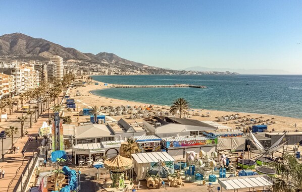 Un paysage urbain côtier avec une plage, des hôtels et un parc.