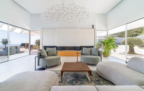A modern living room with a sofa set, a coffee table, and a unique ceiling light fixture.