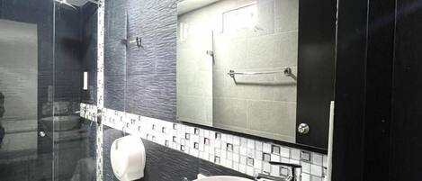 Un baño moderno con inodoro, lavamanos y ducha.