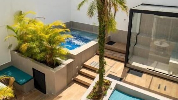 A rooftop terrace with a hot tub, seating areas, and a view of the mountains. - Hotel 79 parque del poblado (Medellín)