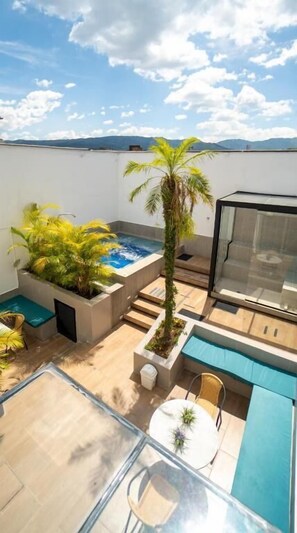 A rooftop terrace with a hot tub, seating areas, and a view of the mountains. - Hotel 79 parque del poblado (Medellín)