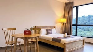 A hotel room with a bed, a table, two chairs, a lamp, and a view of the outdoors. - Forte Seasons Mossaz Premium Suites Petaling Jaya by BYON (Petaling Jaya)