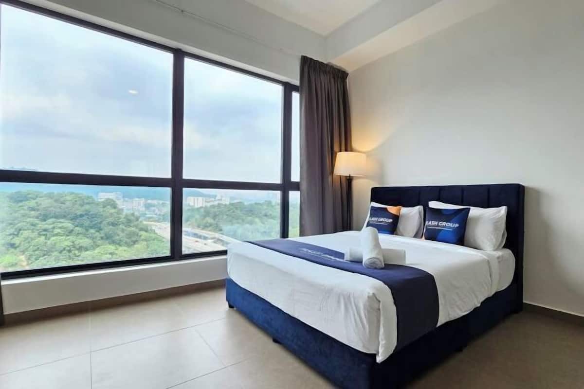 A hotel room with a large window, a bed with a dark headboard, and a view of a cityscape.