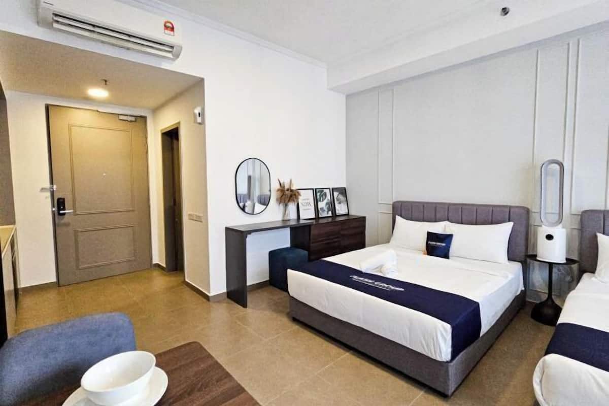 A hotel room with a bed, bedside table, and a chair.
