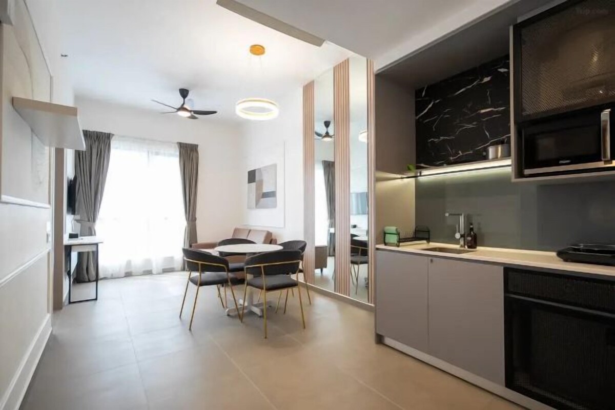 A modern kitchen with a microwave, stove, and cabinets. There is a dining area with a table and chairs.