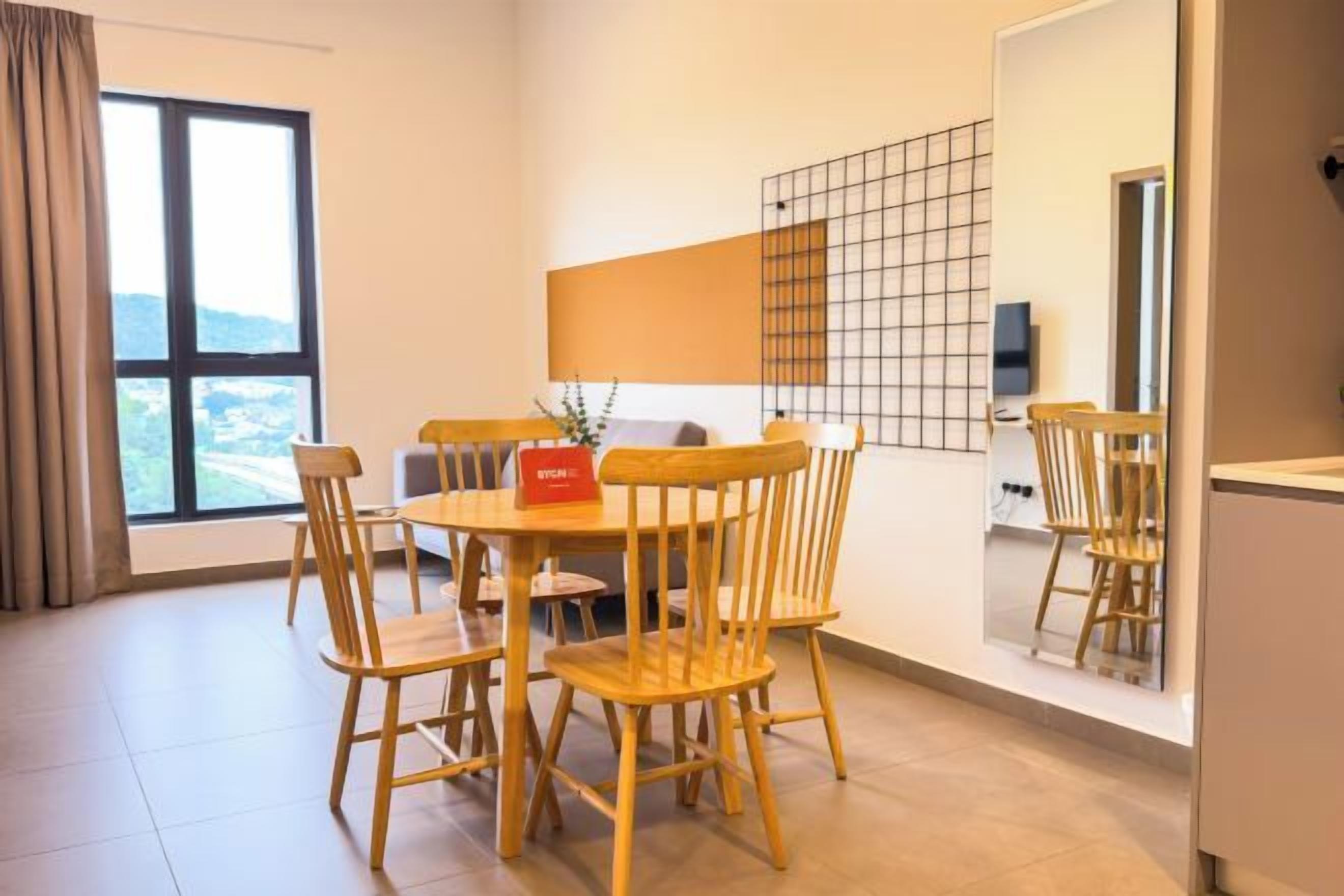 A dining area with a round table and six chairs, a large window with a view, and a wall-mounted TV.