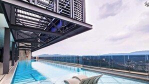 A rooftop infinity pool with a clear view of the city skyline and a distant mountain range. - Forte Seasons Mossaz Premium Suites Petaling Jaya by BYON (Petaling Jaya)