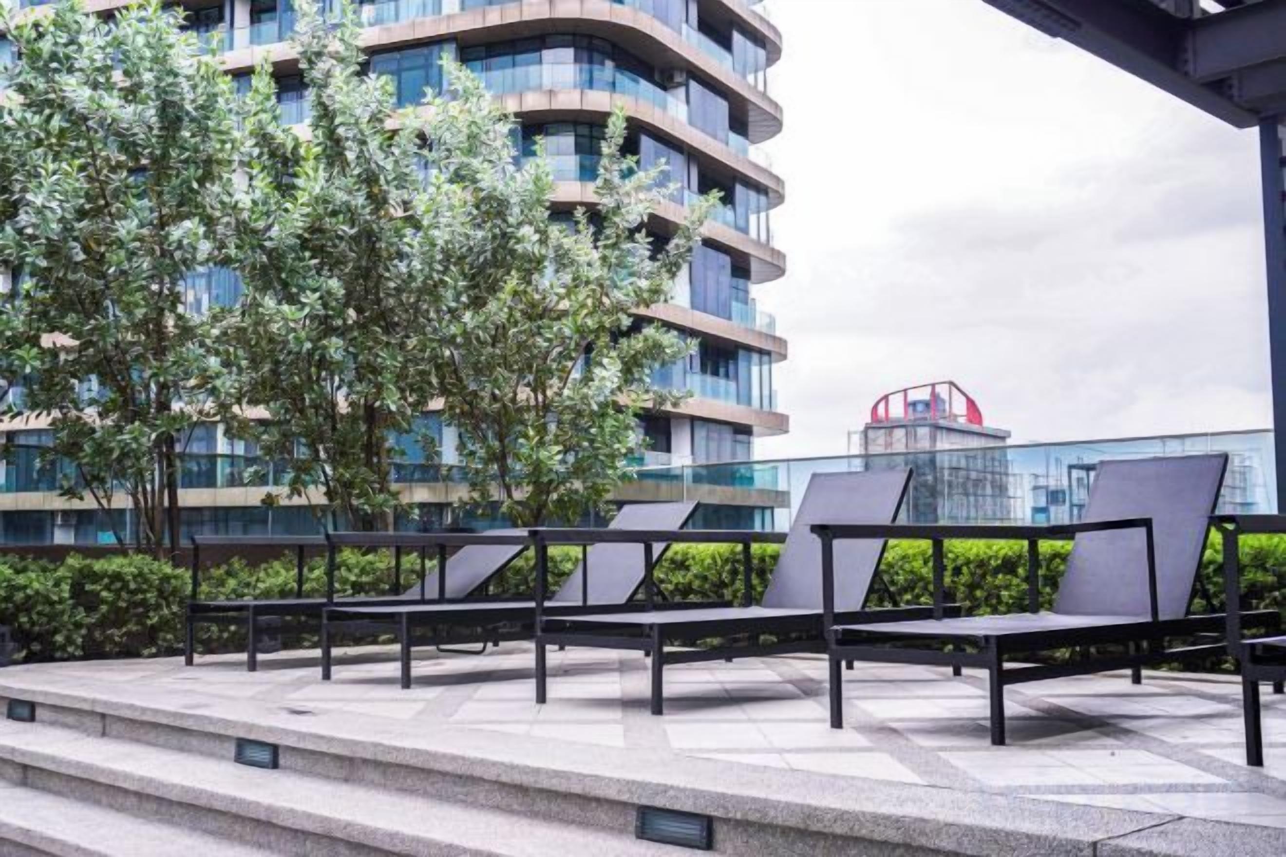 Outdoor seating with steps leading up to a modern building with multiple floors.