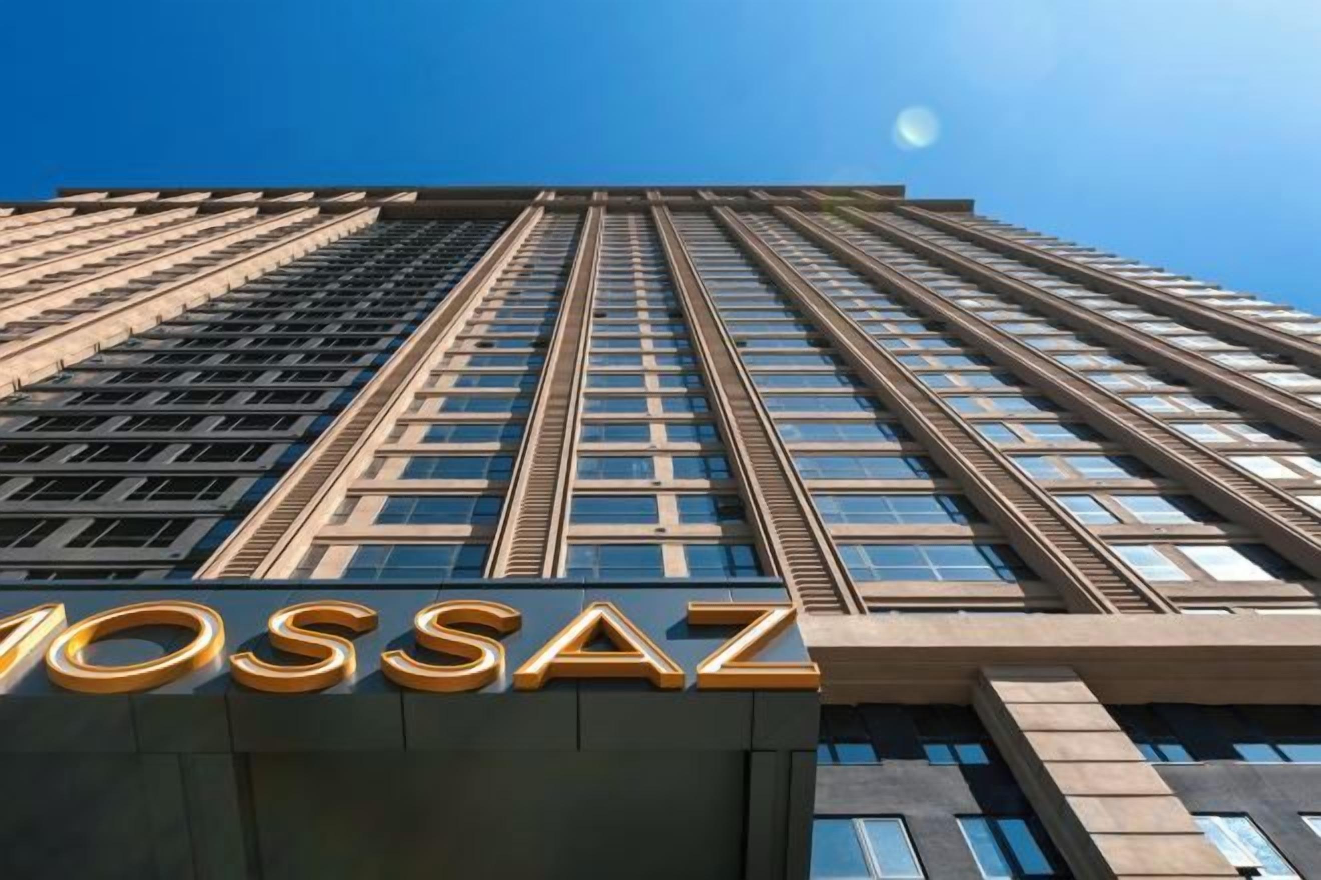 A high-rise building with the name 'MOSSAZ' prominently displayed at the base.