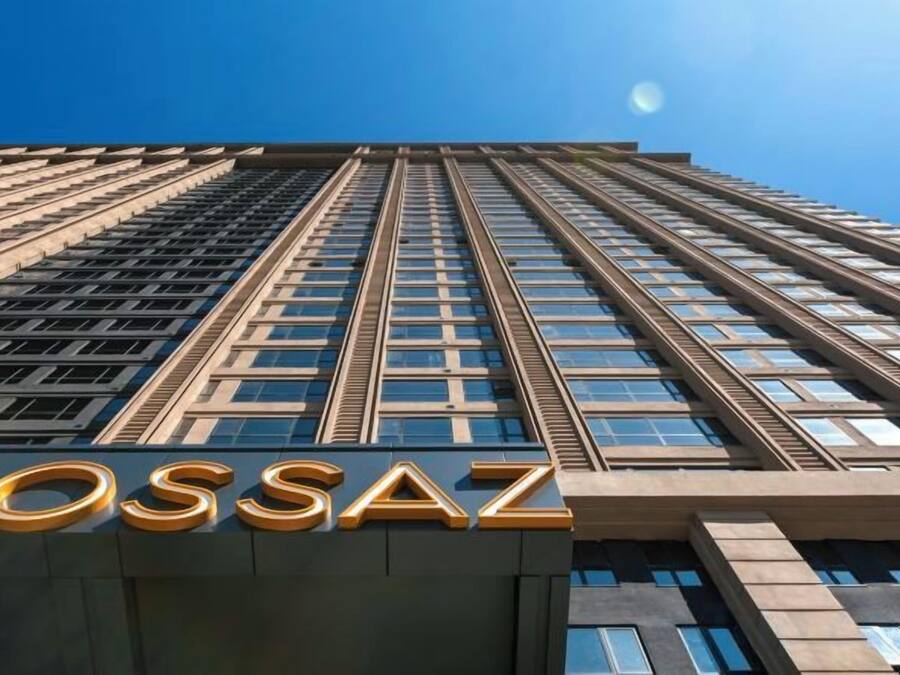 A high-rise building with the name 'MOSSAZ' prominently displayed at the base.