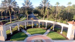 Zona ajardinada con piscina, palmeras y un arco blanco que dice "EMERALD ISLAND".