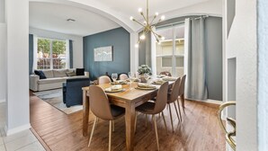 Un comedor con una mesa de madera dispuesta para seis personas, rodeada de sillas.