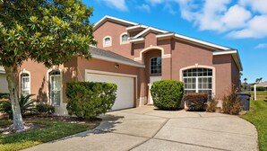 A two-story house with a garage, a driveway, and well-maintained landscaping.