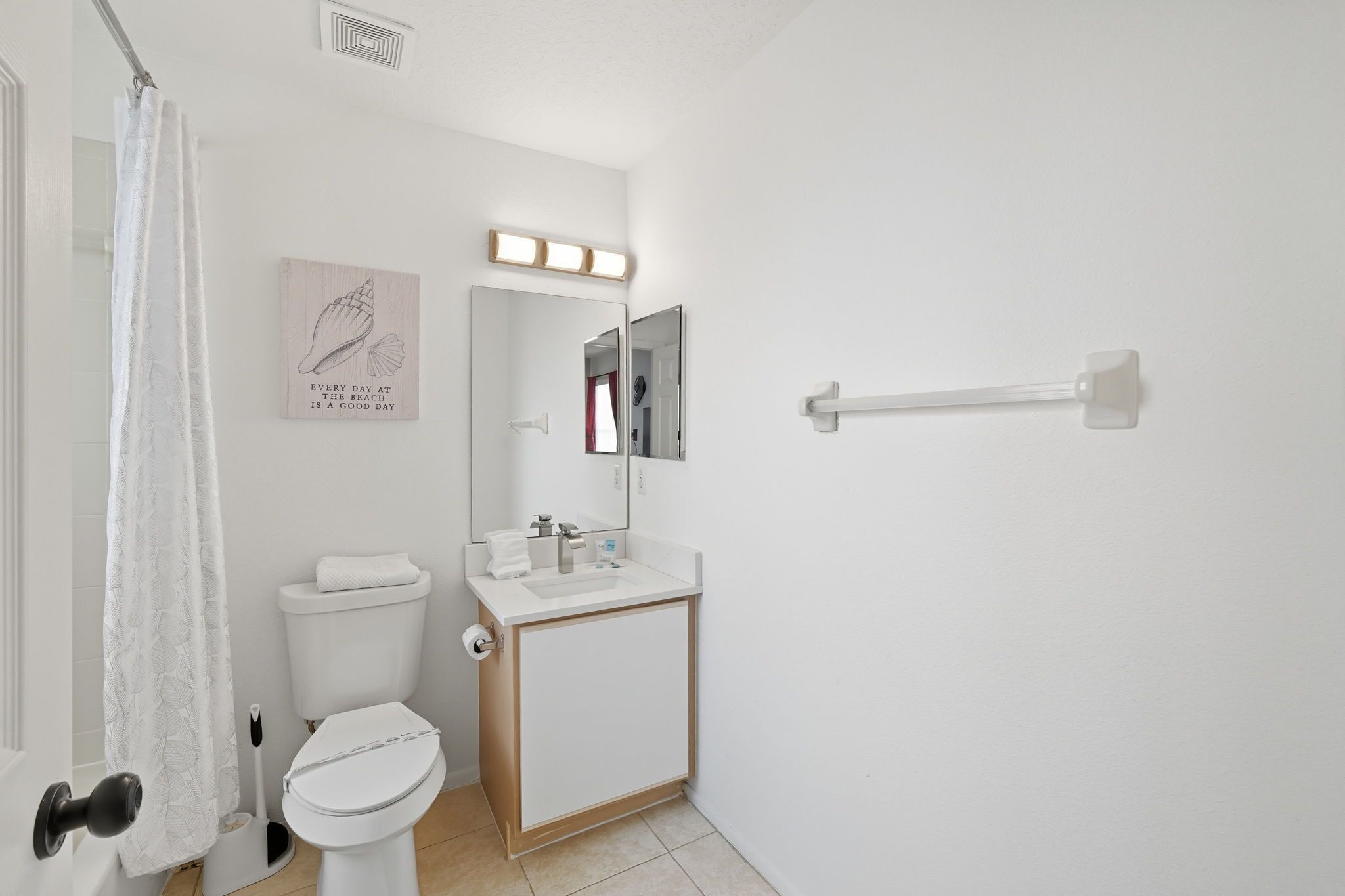 Une salle de bain avec des toilettes, un lavabo et un miroir.