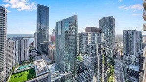 Un quartier urbain caractérisé par de grands immeubles modernes, un ciel dégagé et une vue sur la mer.
