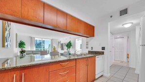 Une cuisine moderne avec des meubles en bois, un plan de travail en granit et une vue sur la ville.
