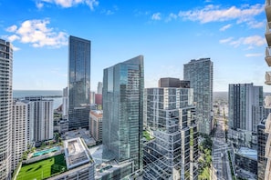 Un quartier urbain caractérisé par de grands immeubles modernes, un ciel dégagé et une vue sur l’océan.
