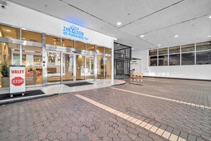 A hotel entrance with a valet stop sign, a glass door entrance, and a sign for 'The Club at Brickell Bay.'