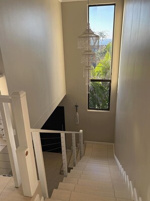 Una escalera con vistas a la vegetación a través de una ventana.