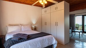 A bedroom with a bed, a wardrobe, a ceiling fan, and a view of the outdoors. - Sea Vista - Awesome Sea Views (uMhlanga)