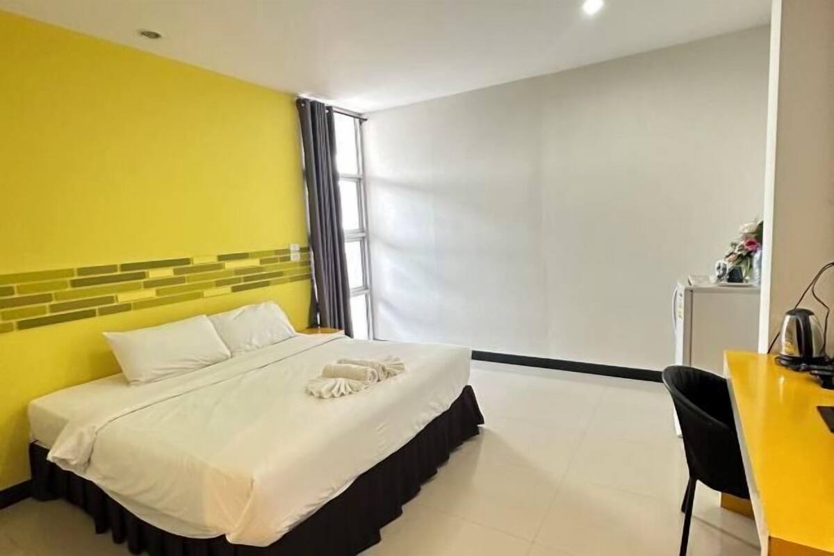 A hotel room with a bed, a desk, and a chair.