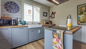 A kitchen with grey cabinets, a microwave, a kettle, and a sink. - 3 bedroom nice apartment in Confolens (Confolens)