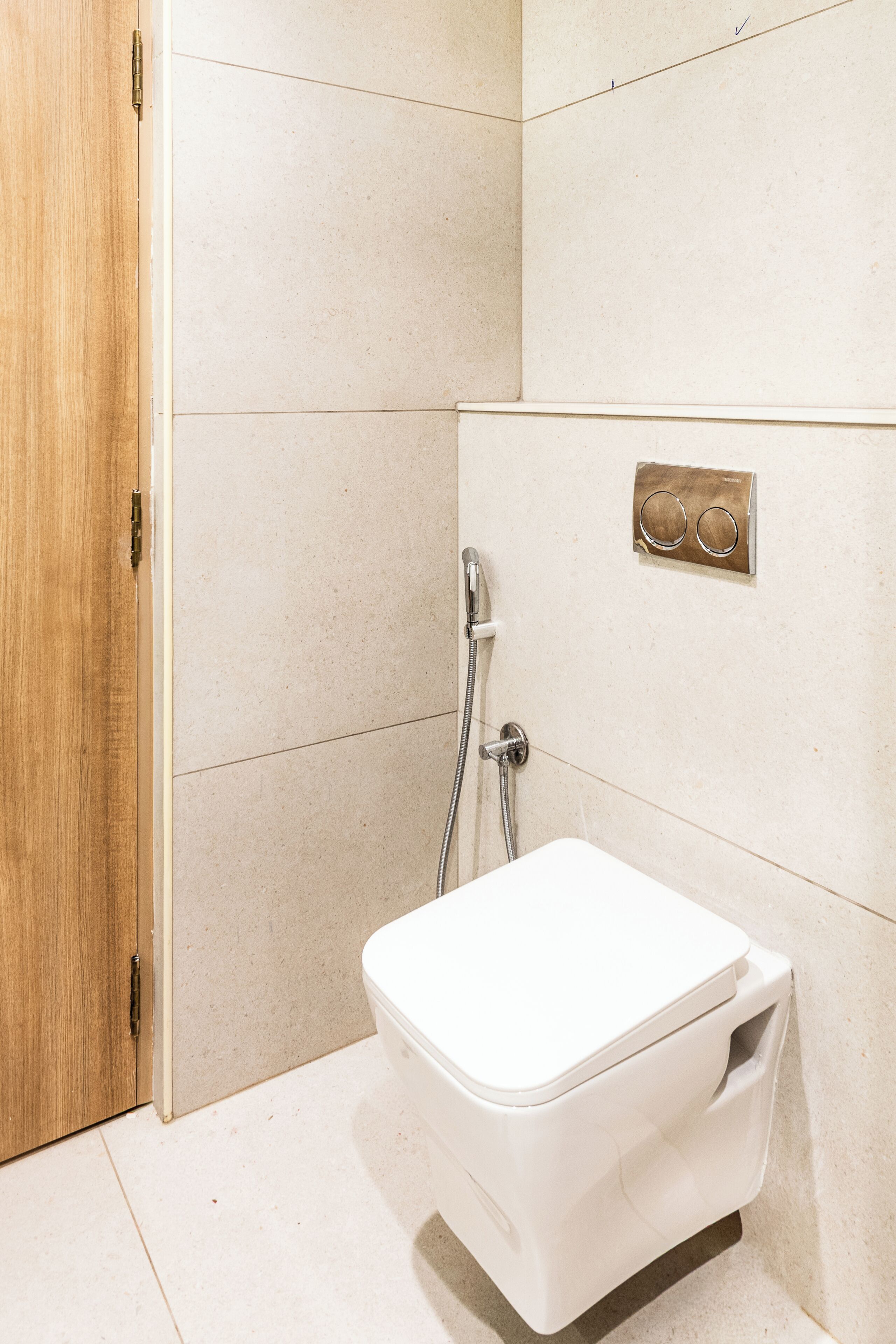 A bathroom with a white toilet, a shower, and a wooden door.