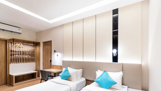 A modern hotel room with two beds, a desk, and a wardrobe. - Hotel Lenexa By Bestinn Leisure (Bengaluru)