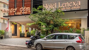 A modern building with a sign for Hotel Lenexa, featuring a logo and name in both English and another language. - Hotel Lenexa By Bestinn Leisure (Bengaluru)
