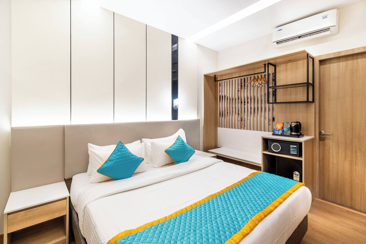 Ein Hotelzimmer mit Bett, Nachttisch, Kleiderschrank und Klimaanlage.