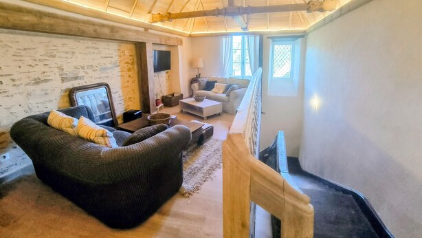 Ein gemütliches Wohnzimmer mit Kamin, einer Couch, einem Couchtisch und einem Fernseher.