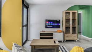 Una sala de estar moderna con un televisor de pantalla plana, un mueble de madera y un sofá.