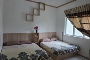 A bedroom with two beds, a window with curtains, a shelf with a vase, and a wooden headboard. - Barakah Sufi Home Stay Apartment Cameron (Tanah Rata)
