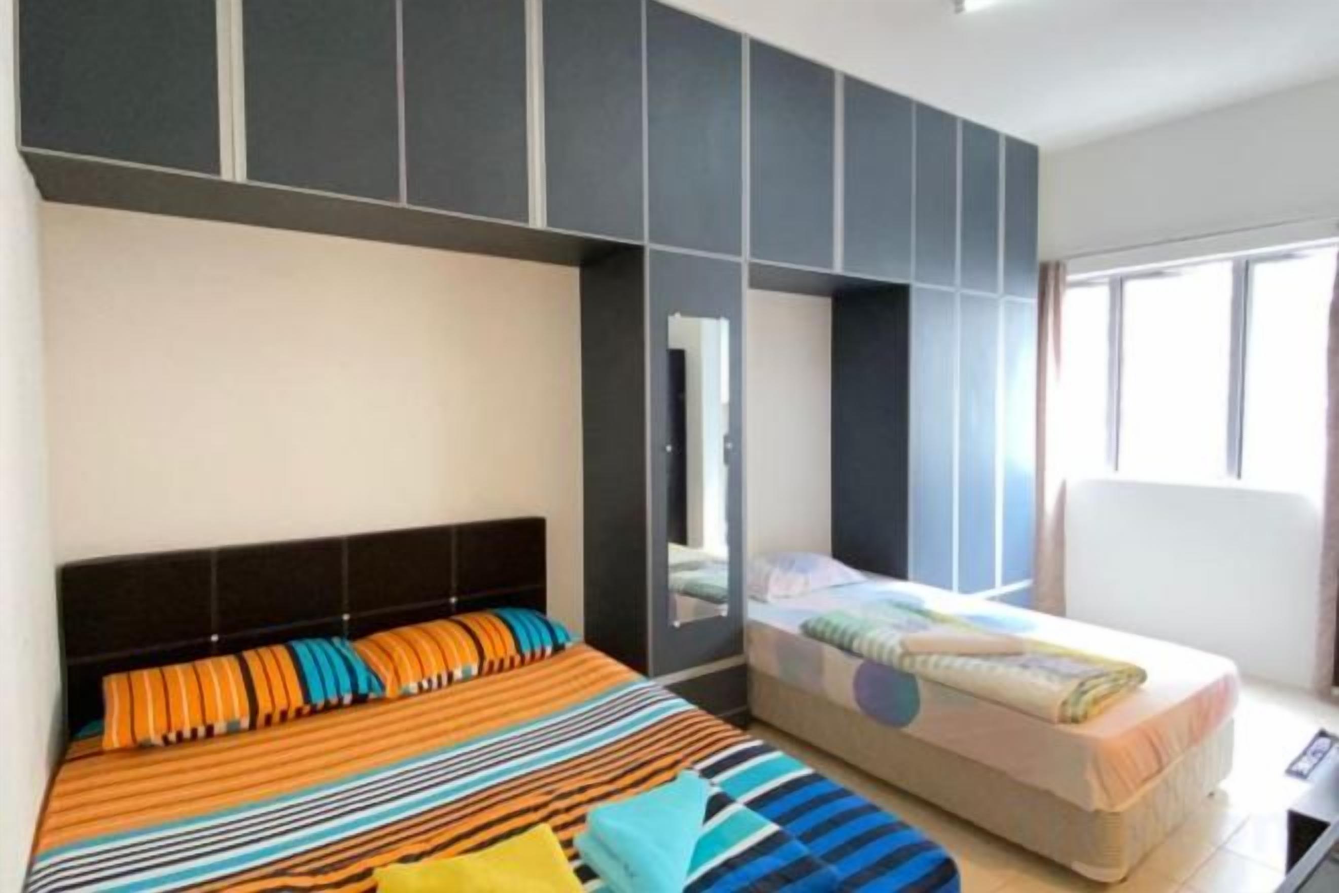 A bedroom with a large bed, a smaller bed, and built-in storage.