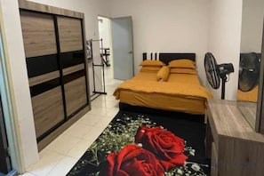 A bedroom with a bed, a wooden wardrobe, a fan, and a door. - Barakah Sufi Home Stay Apartment Cameron (Tanah Rata)
