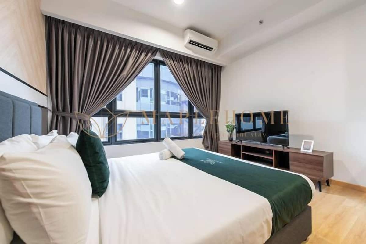 Una habitación de hotel moderna con una cama grande, un televisor y un escritorio.