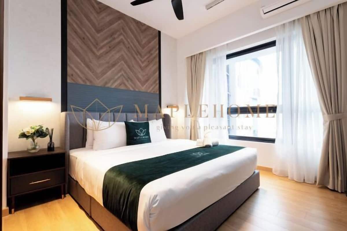 Habitación de hotel con cama, mesita de noche y ventana con cortinas.