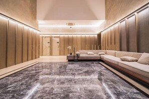 Une chambre d’hôtel avec un sol en marbre, un canapé et un lit.
