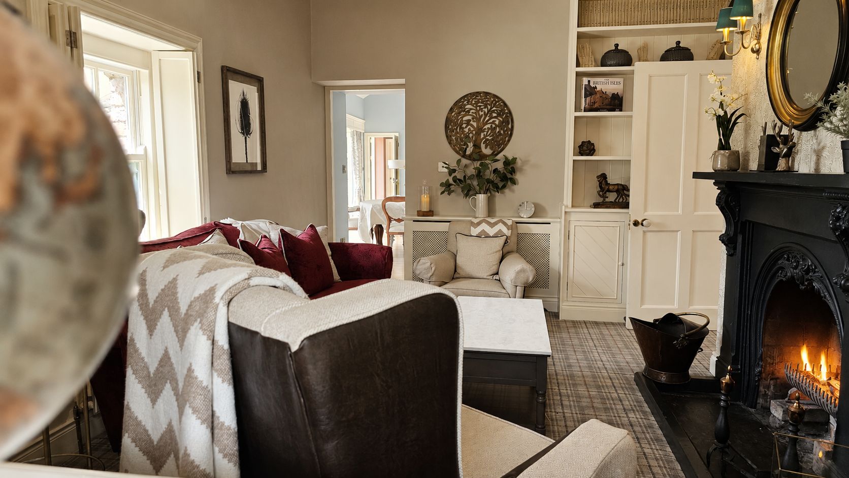 A cozy living room with a fireplace, a sofa, a coffee table, and a bookshelf.