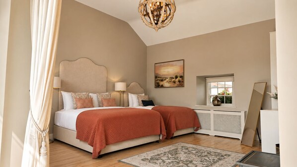 A bedroom with a bed, bedside lamps, a painting, a radiator, and a window.