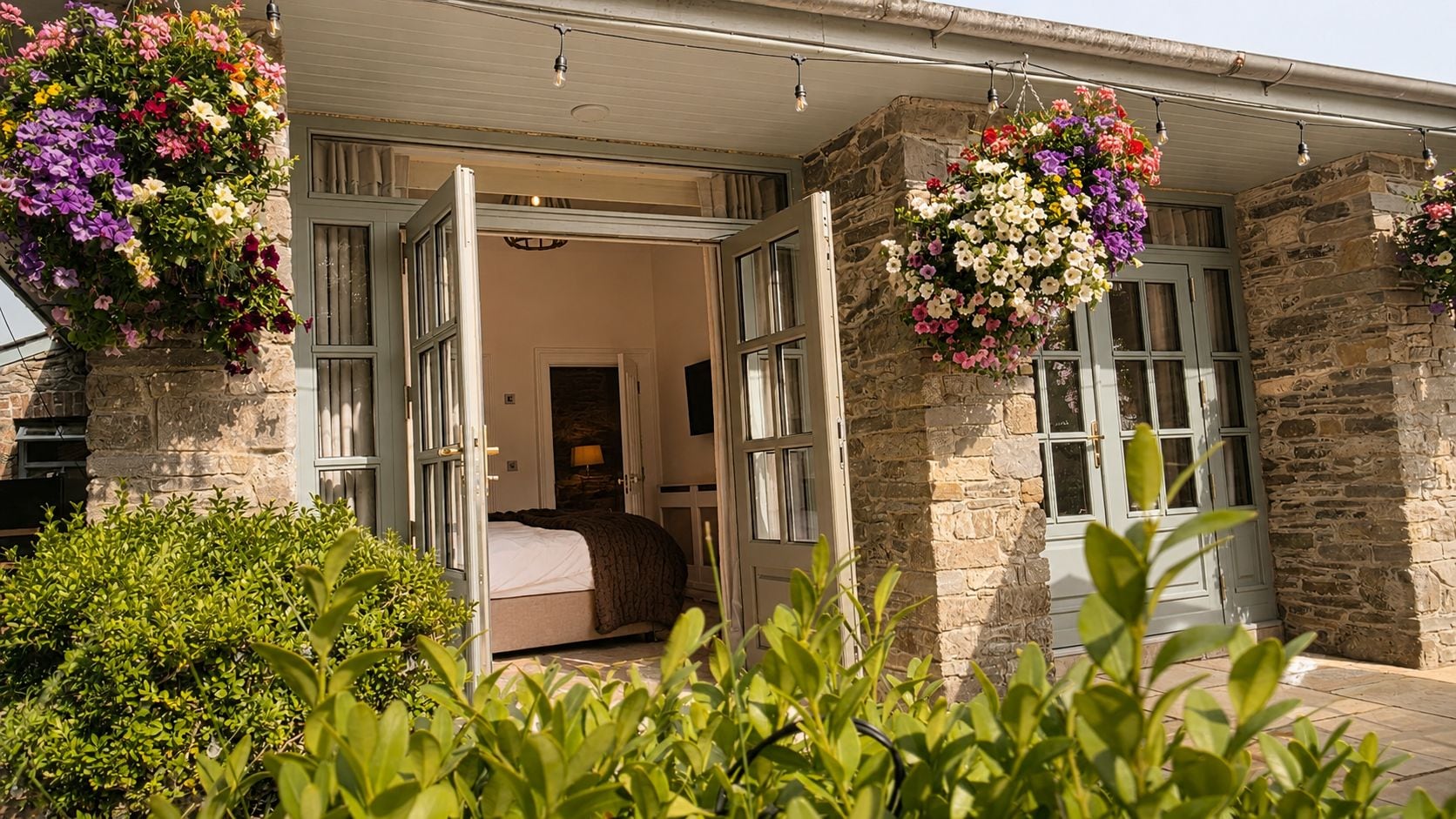 A hotel room with an open door, a bed, and a stone exterior.
