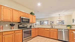 A kitchen with wooden cabinets, stainless steel appliances, and a granite countertop. - Blackfoot Two San Tan Valley (San Tan Valley)