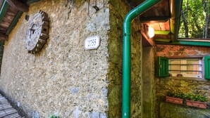 A rustic stone wall with a water wheel, a sign reading "Via del Trescolle," and a green pipe running along the wall. - 2 bedroom stunning home in Casoli (Casoli)
