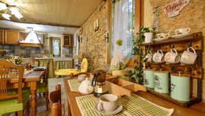 A rustic kitchen with wooden furniture, a coffee station, and a dining area with a checkered tablecloth. - 2 bedroom stunning home in Casoli (Casoli)