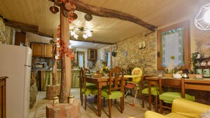 A rustic kitchen with a stone wall, wooden furniture, and a brick oven. - 2 bedroom stunning home in Casoli (Casoli)