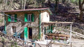 A rustic stone house with green shutters, a wooden deck, and outdoor seating. - 2 bedroom stunning home in Casoli (Casoli)